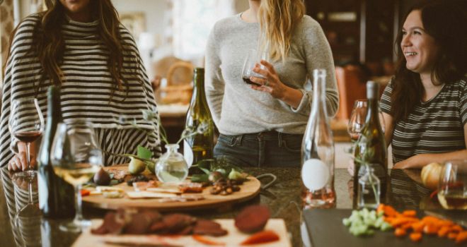 3 woman smiling and having a good time at the party, while eating food